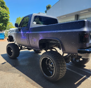 Lifted Chevrolet pickup with a color-shifting finish after detailing