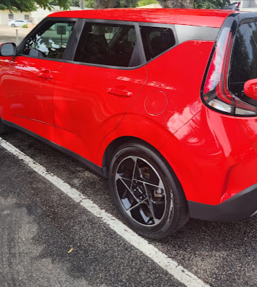 Red SUV rear three-quarter view with a deep glossy paint finish