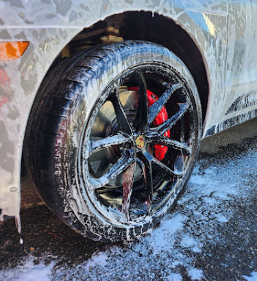 Wheel and brake caliper covered in cleaning foam during decontamination