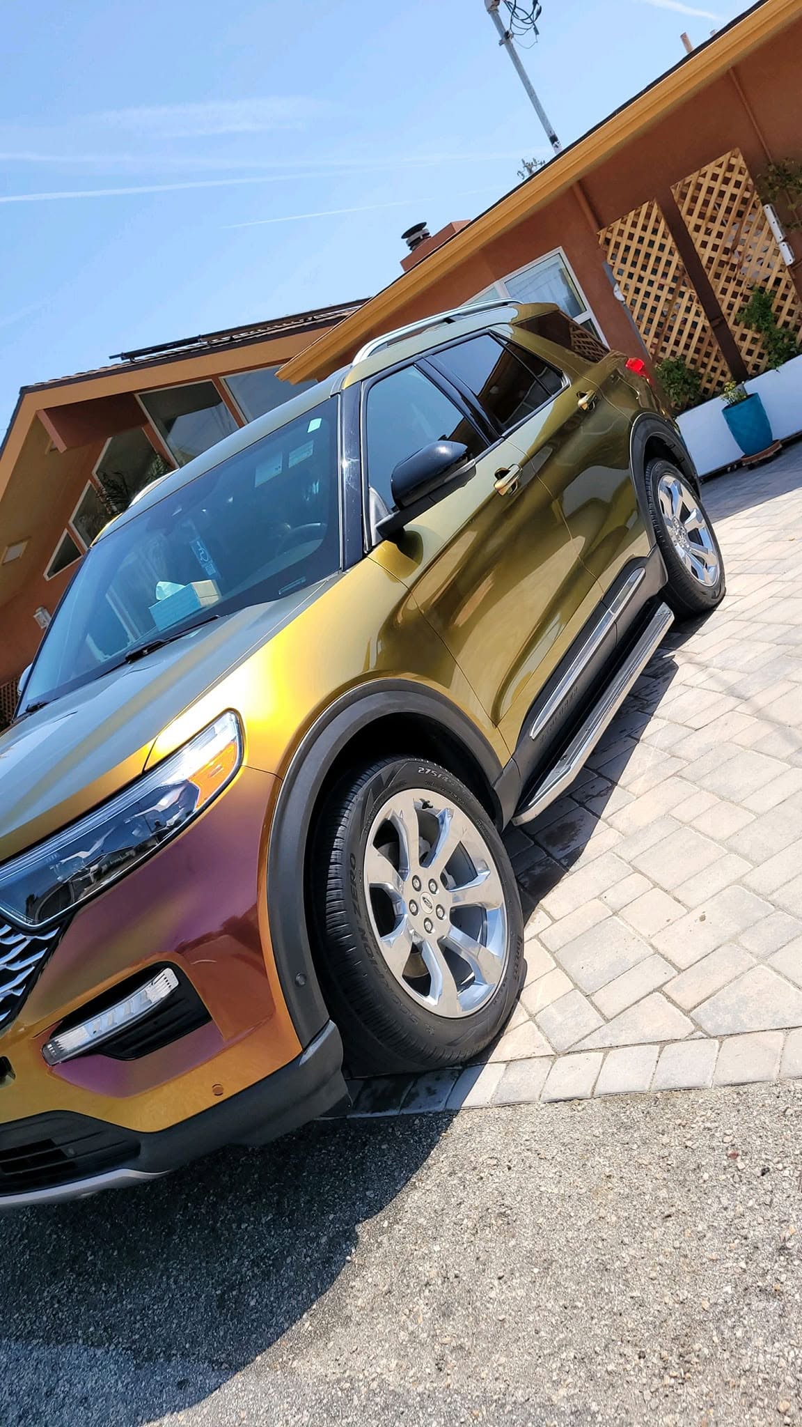 Gold Ford Explorer freshly washed and gloss-finished on a paver driveway