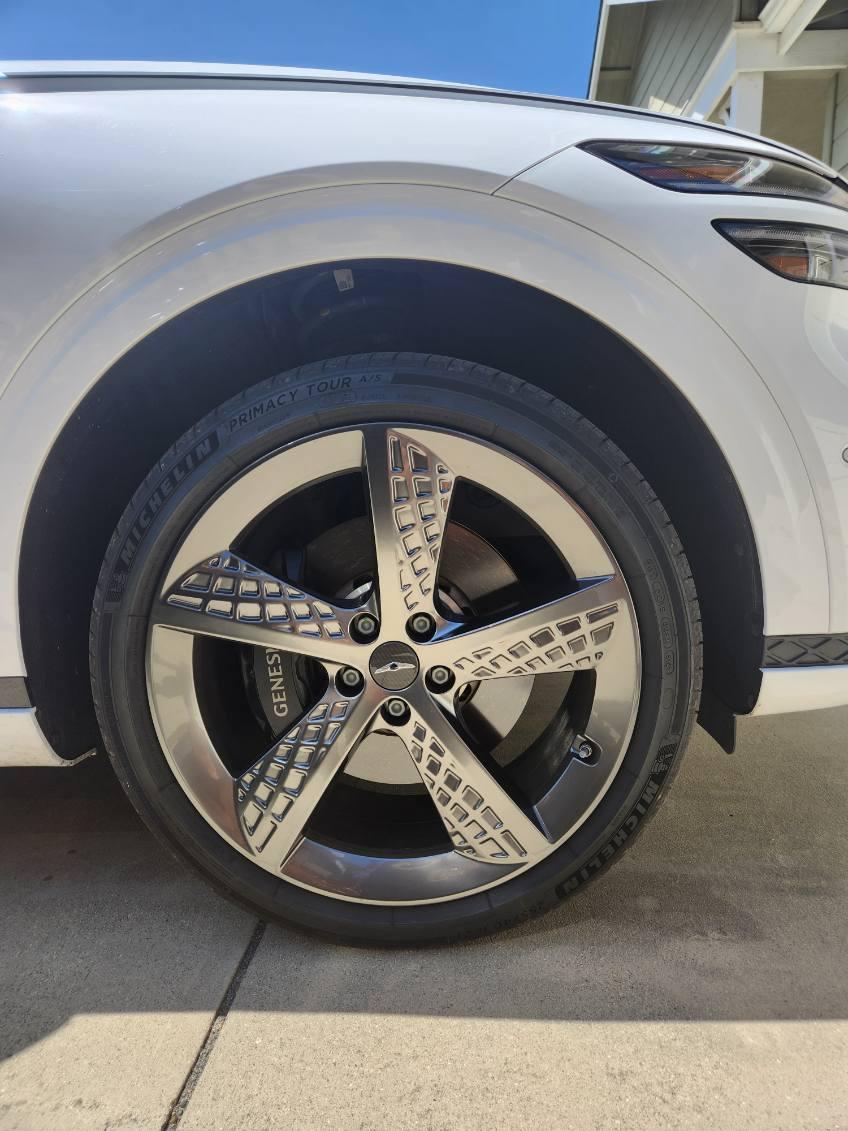 Polished alloy wheel on a white SUV after a deep wheel clean