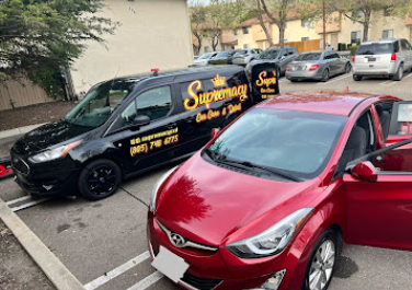 Supremacy van detailing a red Hyundai in a parking lot