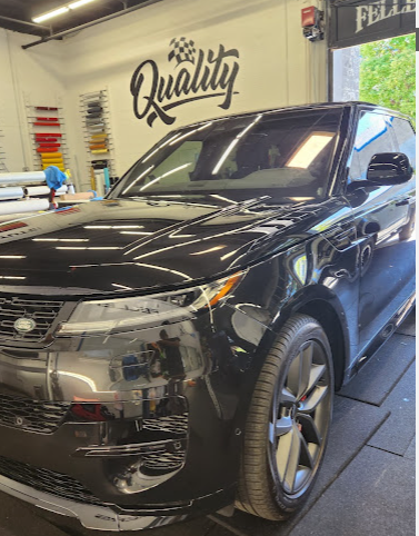 Black Range Rover under shop lighting after paint correction